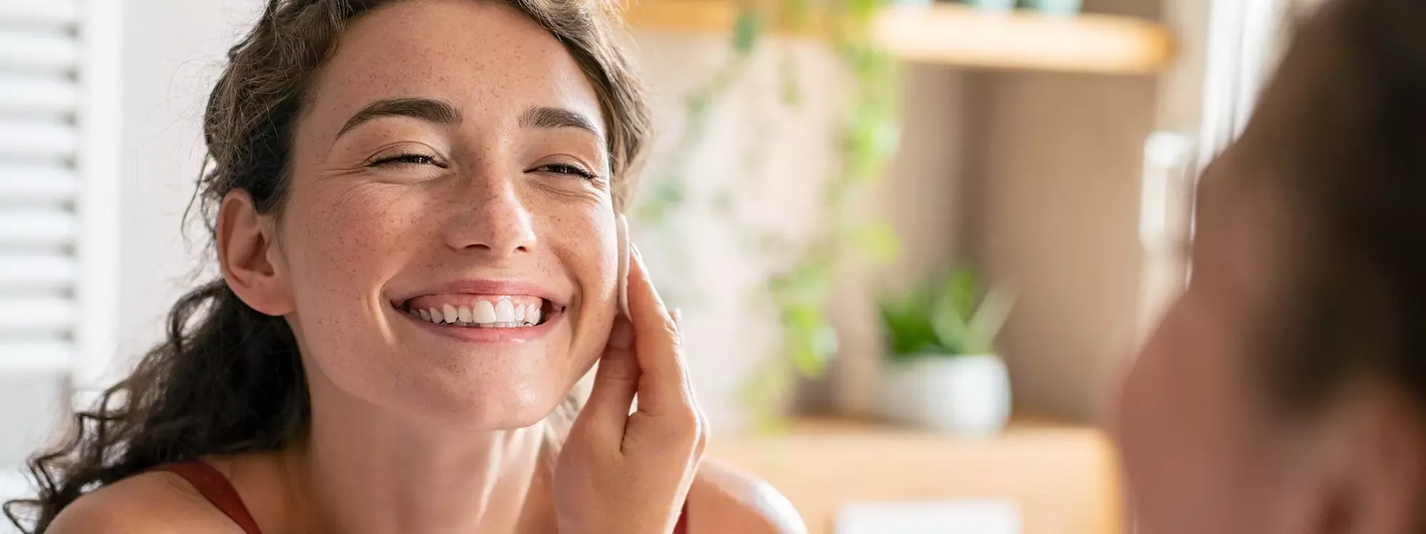 Young woman looking at her smile in the mirror